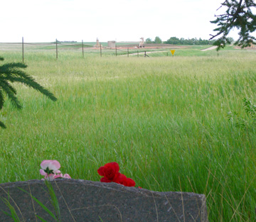 Gravestone with oil well in background